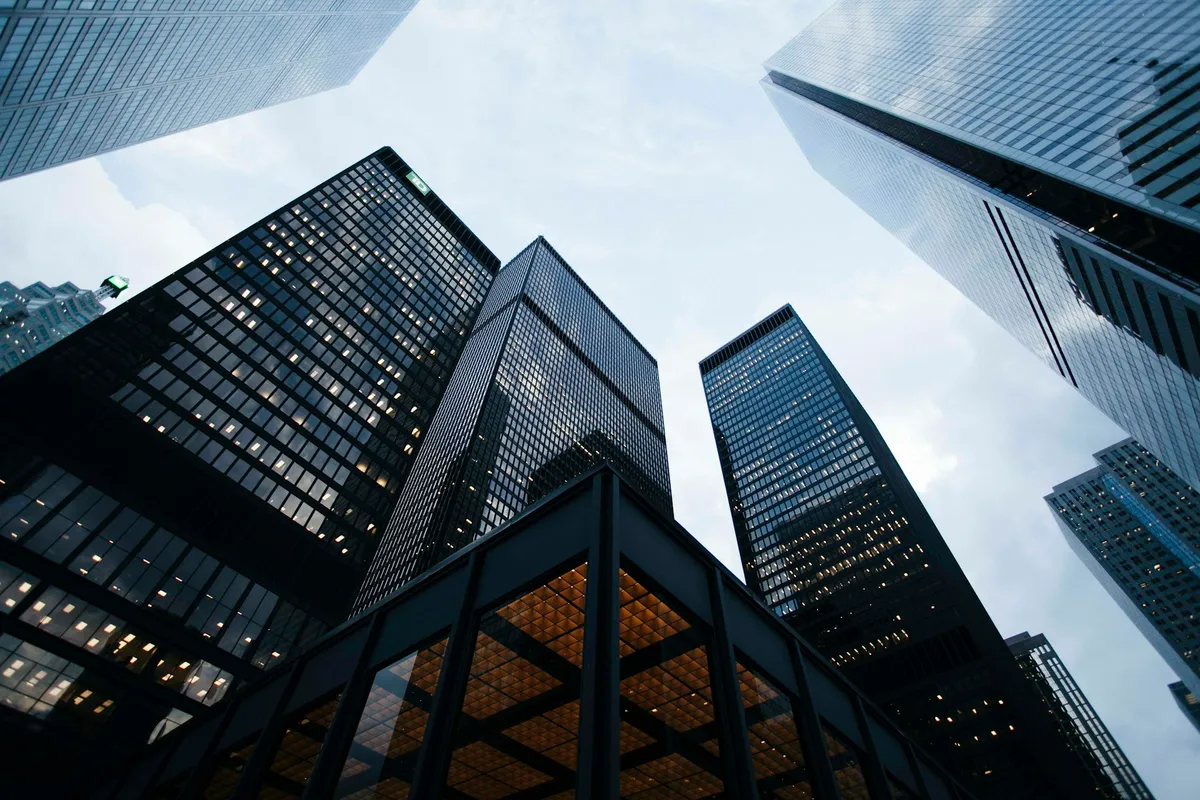 Modern commercial building with glass facade reflecting the sky, representing intelligent building infrastructure